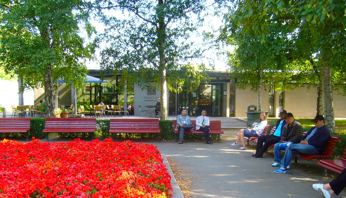 Kafe Vigeland omgitt av trær og blomster ved Frognerparken